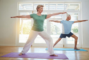 elderly woman and men doing pilates on mats